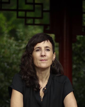 Julie Gazard, accoudée à une rambarde rouge au Jardin de Chine.